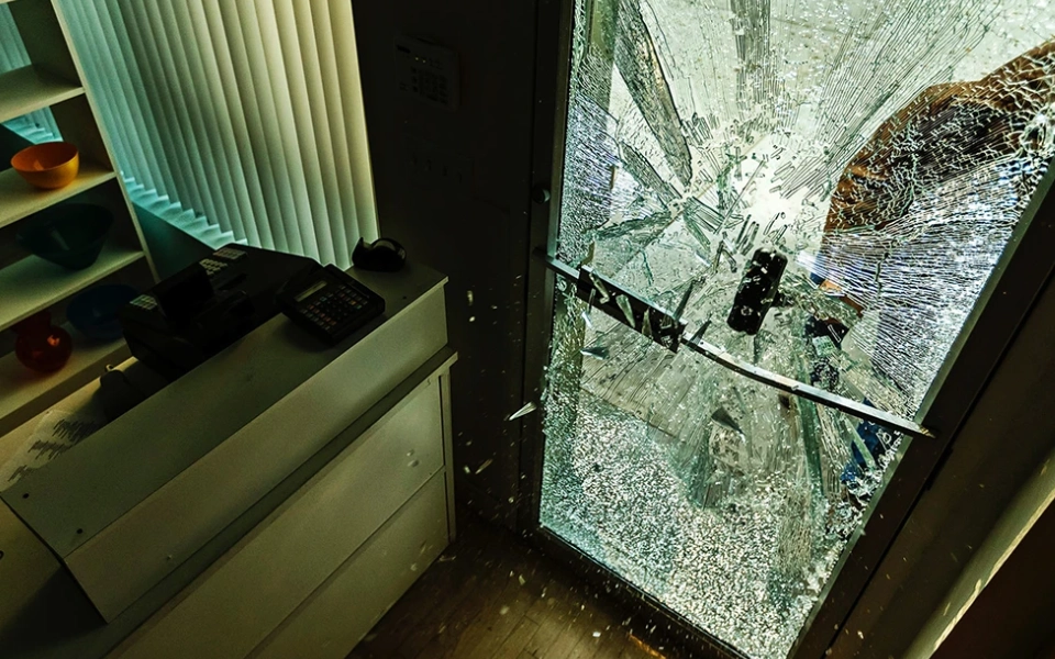 A broken glass door in the corner of a room.