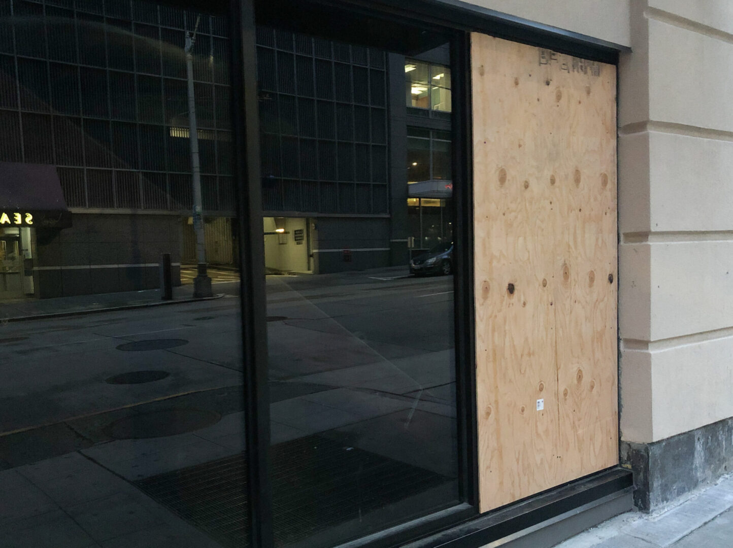 A boarded up window in front of a building.